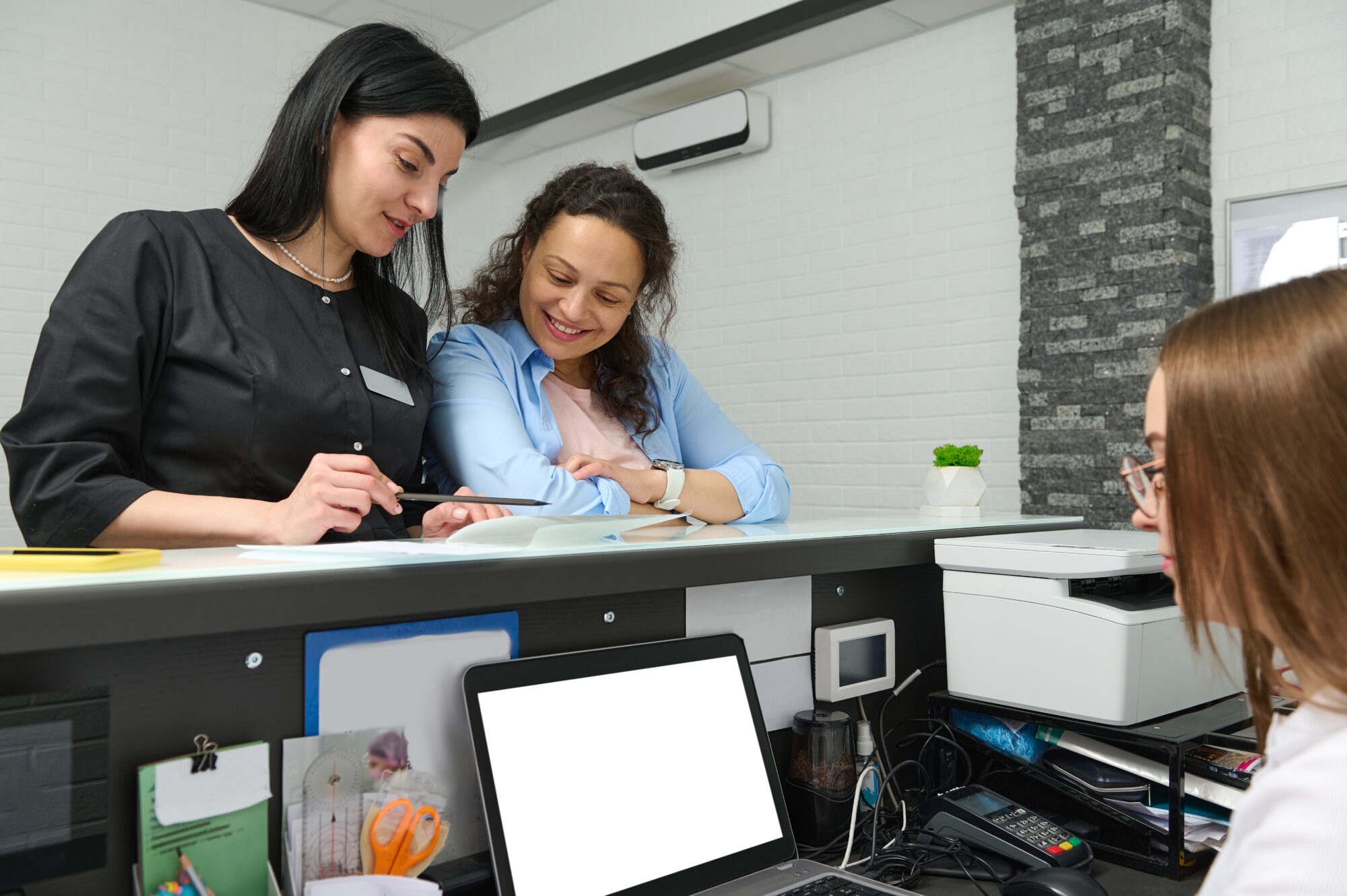 Clients checking in at a dental reception desk.